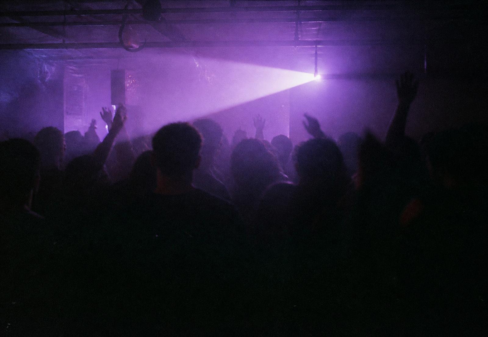 Dunkle Crowd auf einem Rave, Lichtstrahl im Nebel